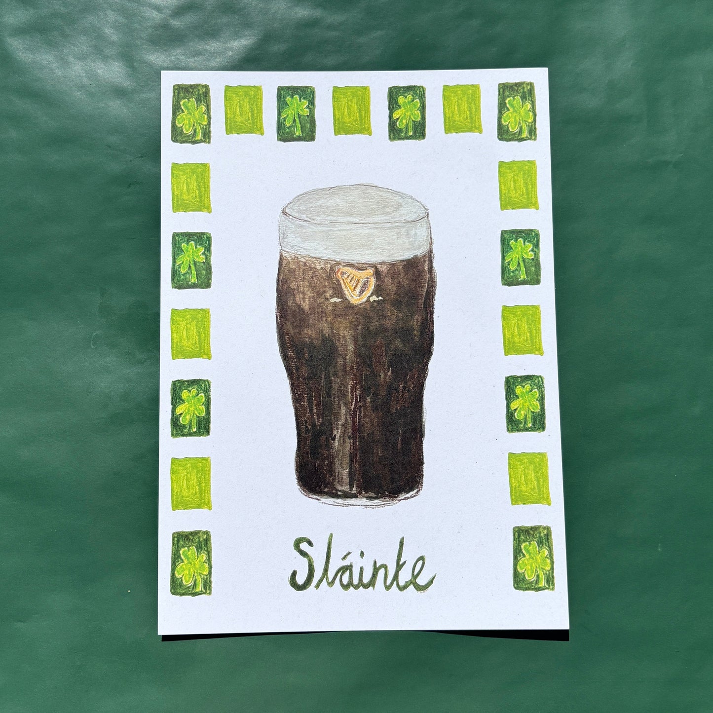 An art print featuring an illustration of a pint of Guinness with a shamrock border