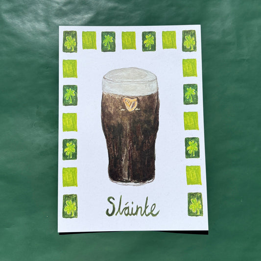 An art print featuring an illustration of a pint of Guinness with a shamrock border