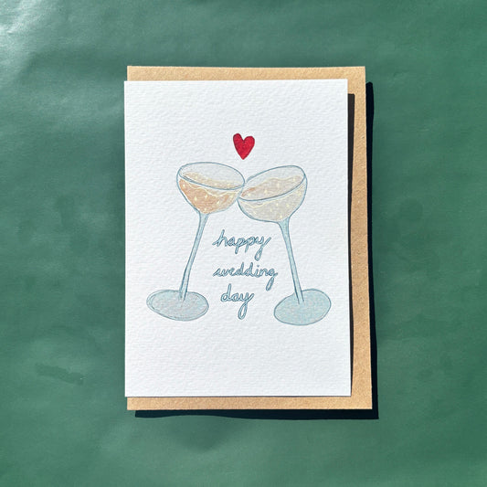 Greeting card with an illustration of two champagne glasses and 'happy wedding day' text