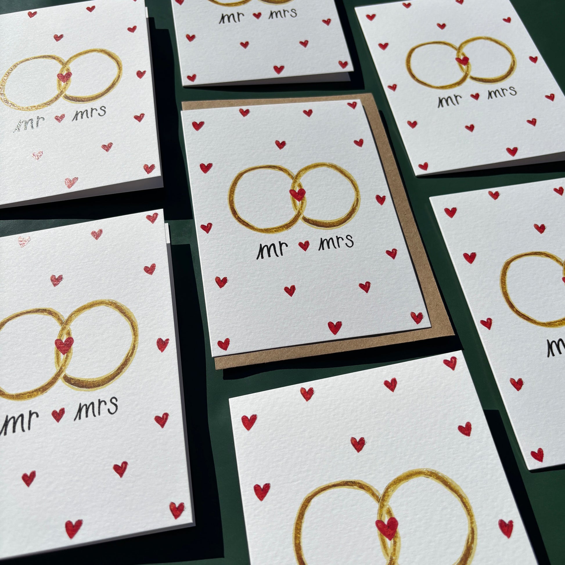 Multiple greeting cards with illustrations of wedding rings and tiny love hearts with 'Mr and Mrs' text.