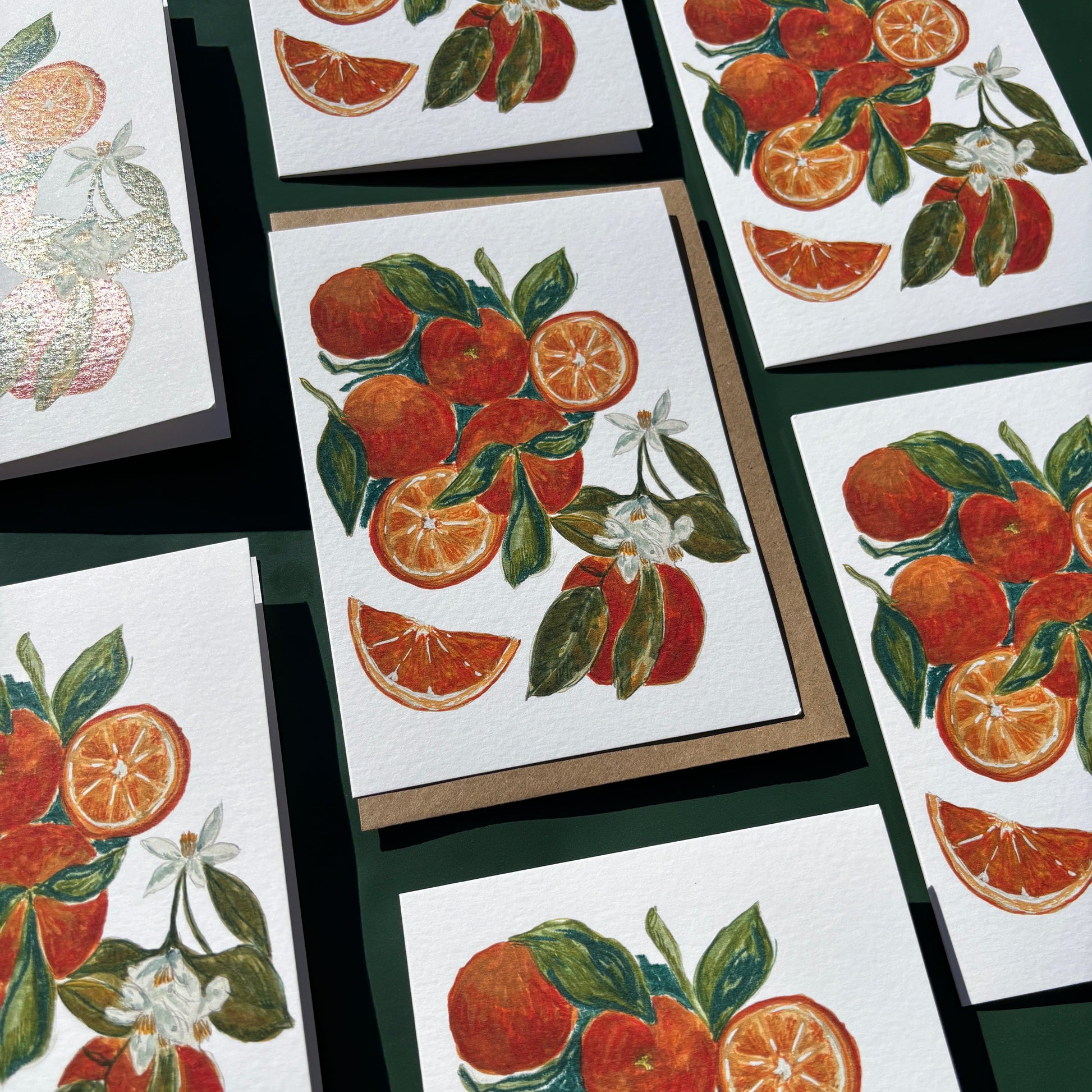 Multiple greeting cards featuring a painting of oranges and flowers