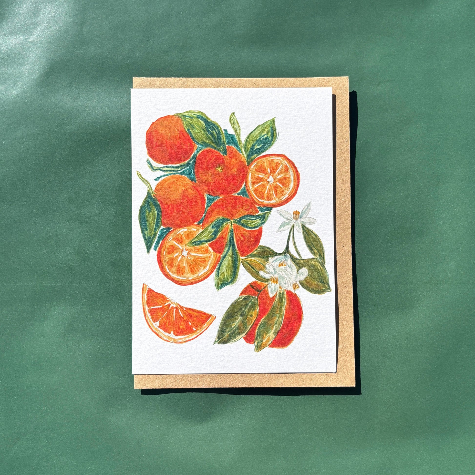 A greeting card featuring a painting of oranges and flowers