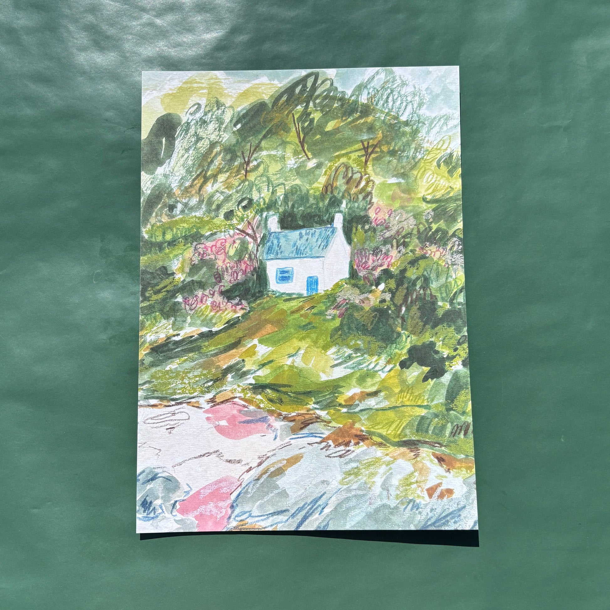 An art print featuring a mixed media painting of a seaside cottage